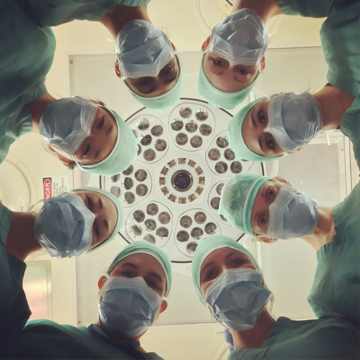 surgeons looking down under operating light